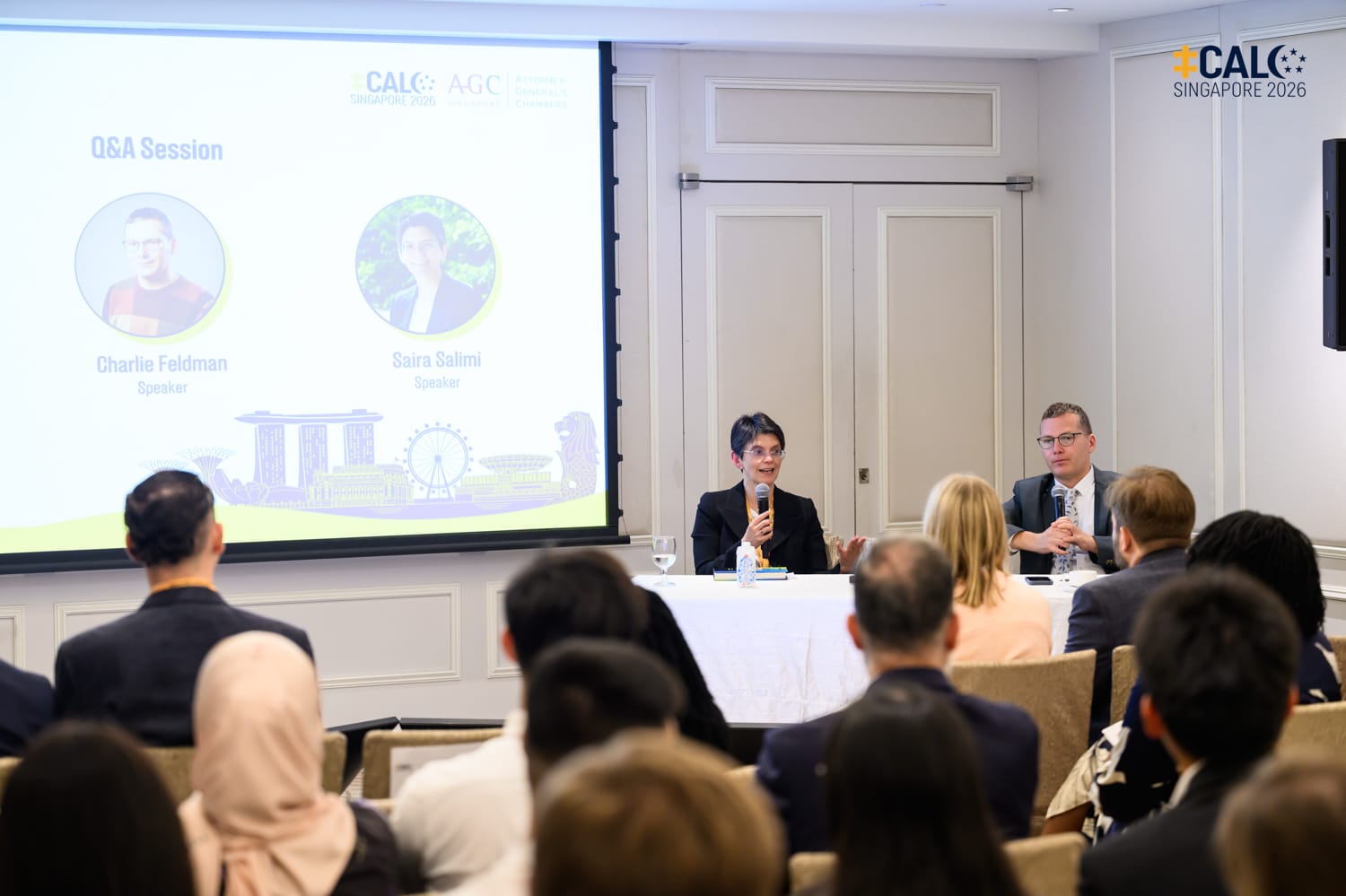 Speakers Saira Salimi and Charlie Feldman during the Q&A session of the Parliaments and procedure panel at the Conference, seated at a table in a breakout room at The Fullerton Hotel Singapore.